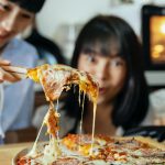 cheerful asian women with fresh baked pizza